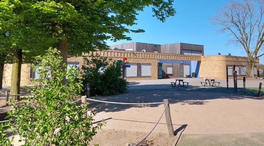 Het speelplein met op de achtergrond het schoolgebouw