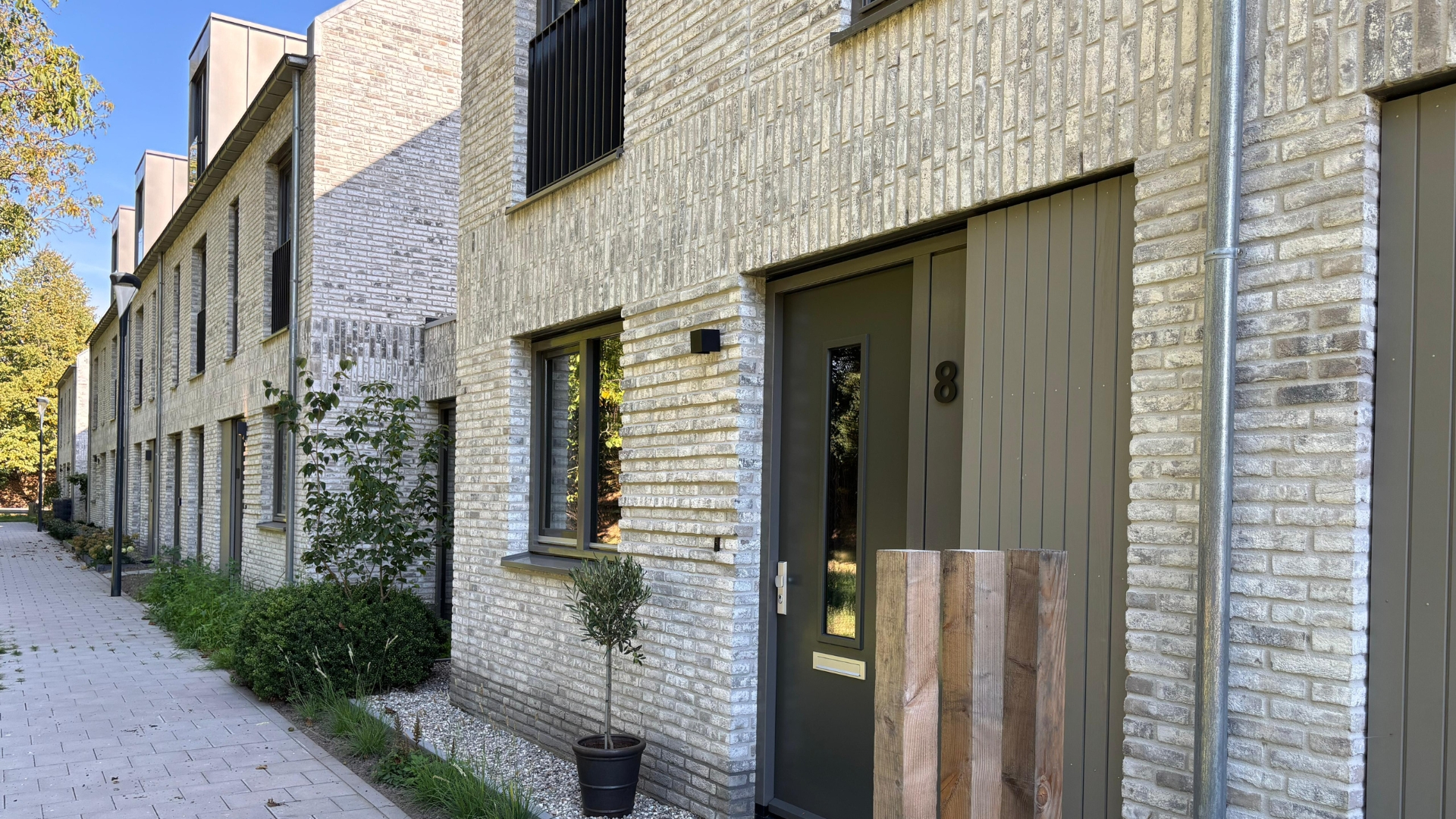 De zinken dakkapellen van de rijwoningen volgen de lijn van de raamopeningen