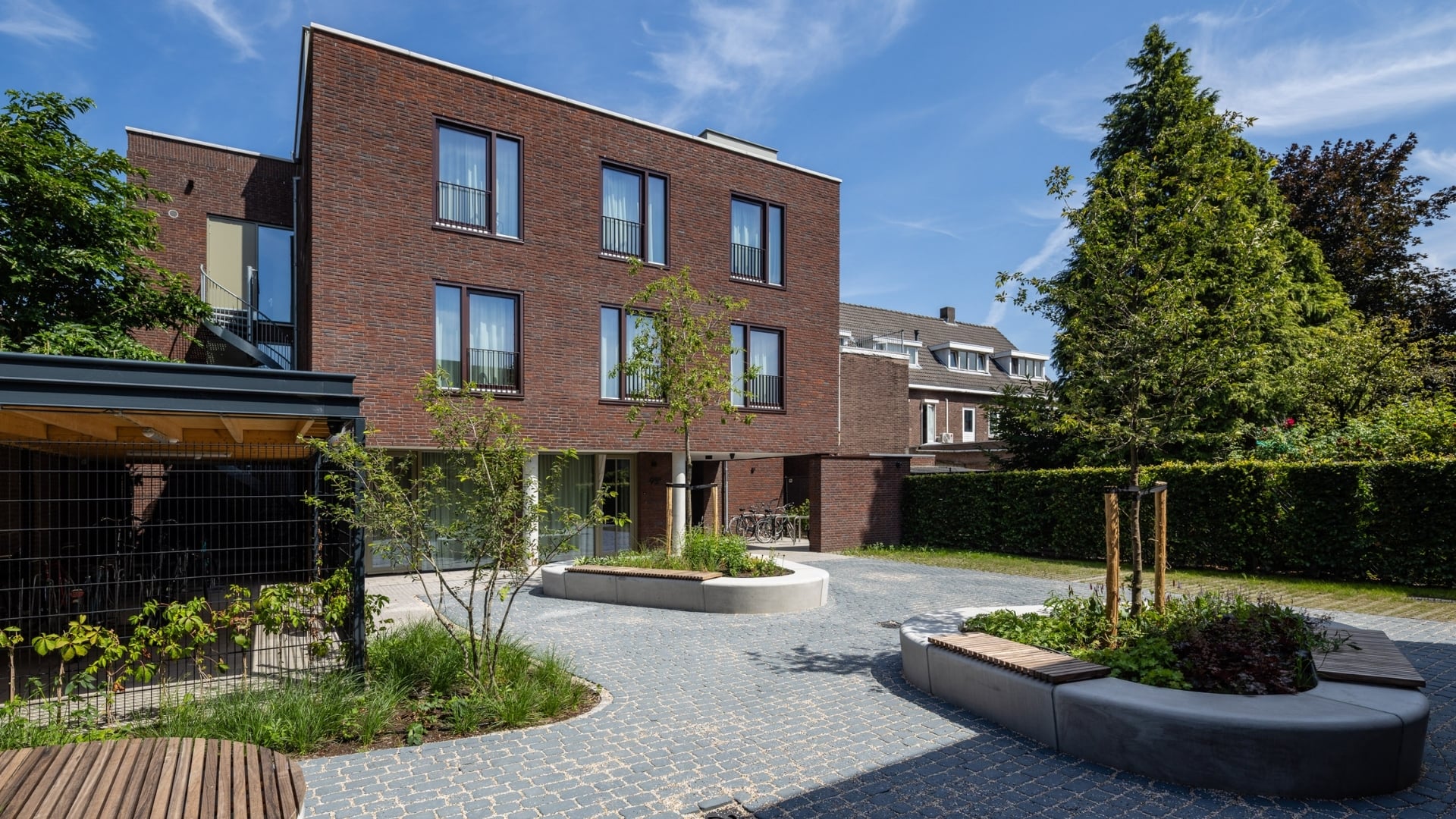 Het groen tussen de twee gebouwen vormt een ontmoetingsplek voor de bewoners