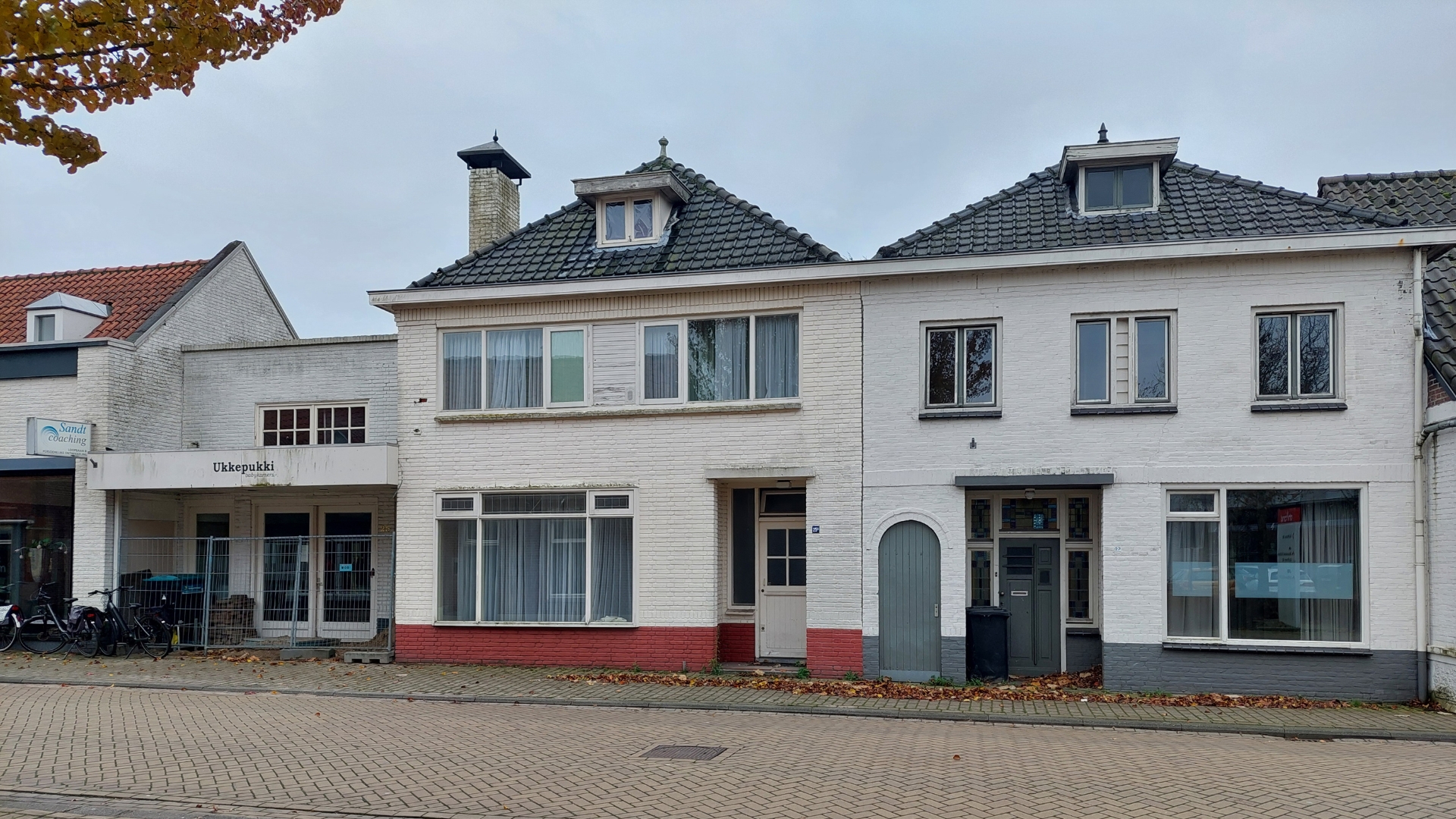 Het aanzicht van de vroegere babywinkel en woningen