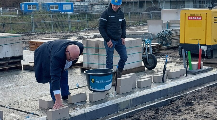 Onder toeziend oog van onze uitvoerder legt wethouder Ben Brands een symbolische eerste steen